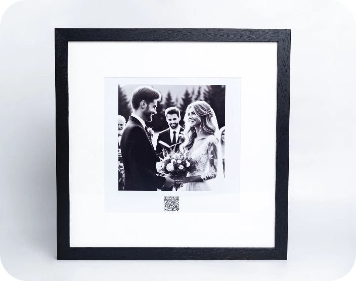 A framed print of a wedding with a QR code below the picture representing our product, a framed print